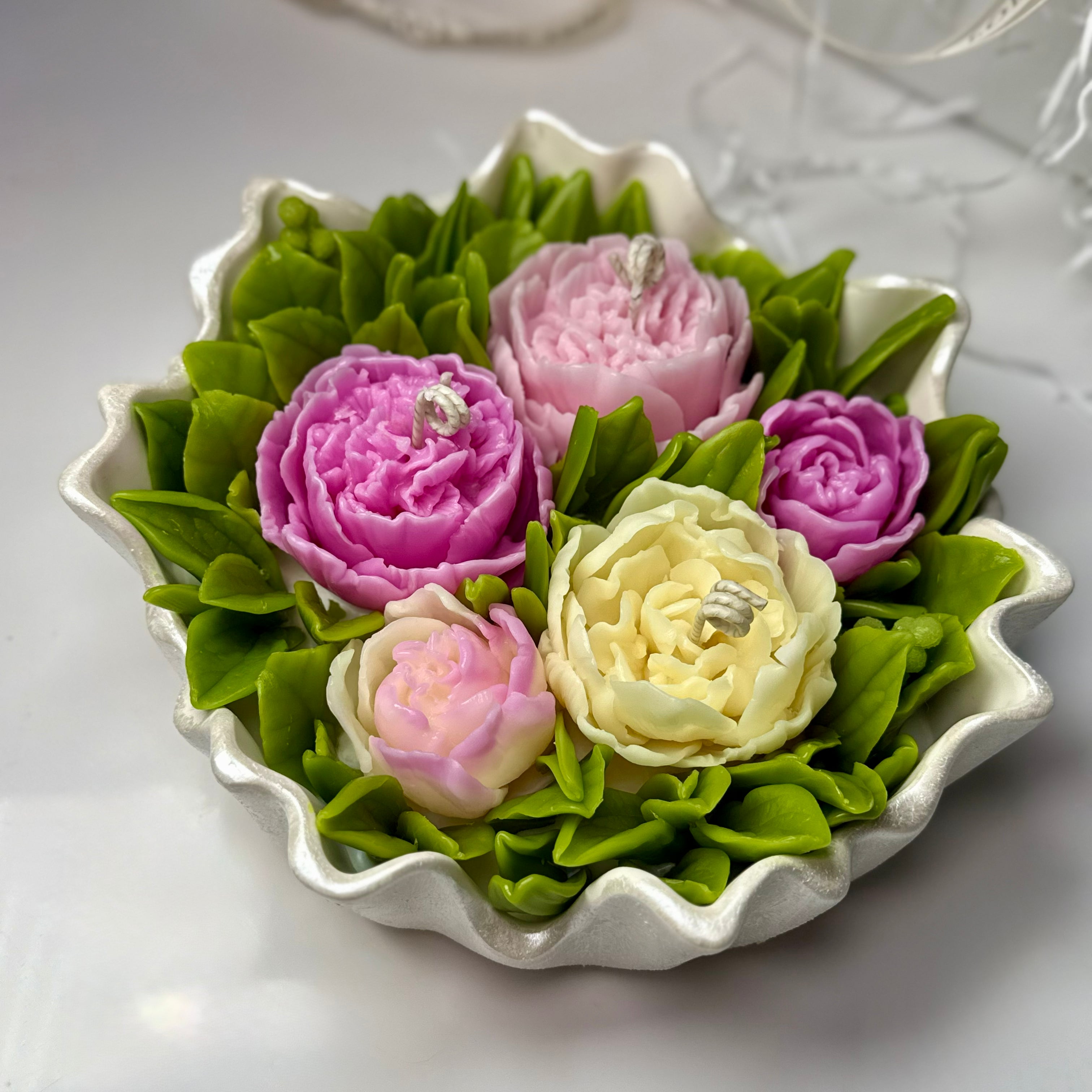 An overhead view of the massive 20cm detailed Sarah Bernhardt peony candle arrangement, showcasing realistic pink and magenta layered petals in a hand-painted pearl white Jesmonite dish.