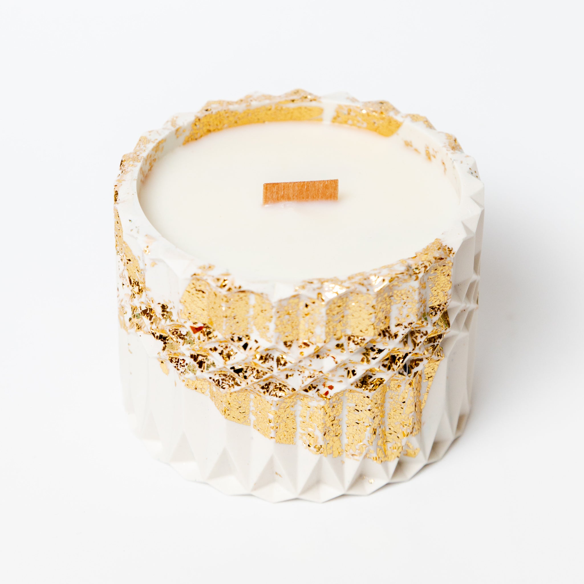 Hand-poured soy wax candle in a white and gold leaf Jesmonite pot, showcasing the luxury artisan finish of the container.