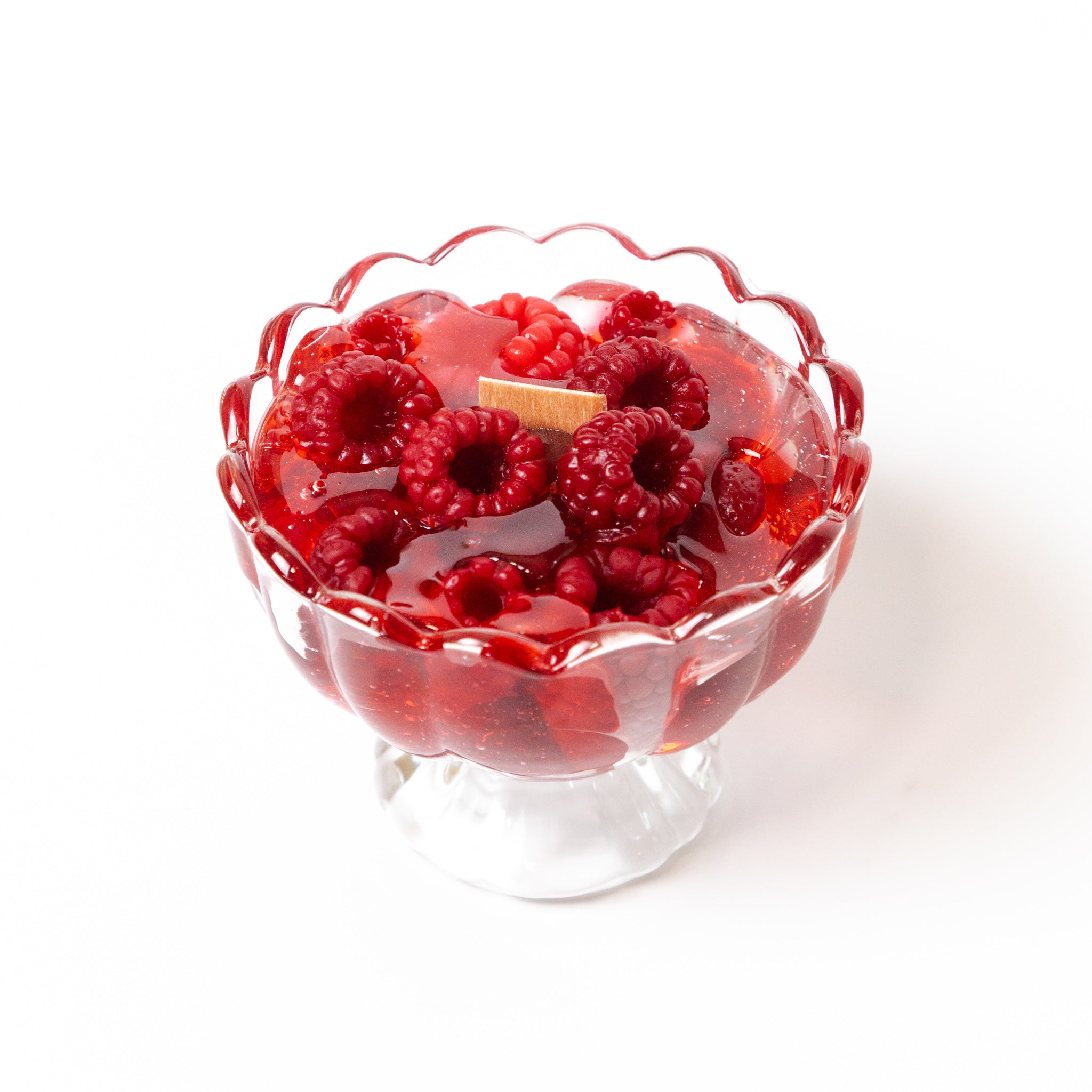 Artisan raspberry-scented gel wax candle crafted in an elegant dessert dish, featuring lifelike decorative beeswax berries.