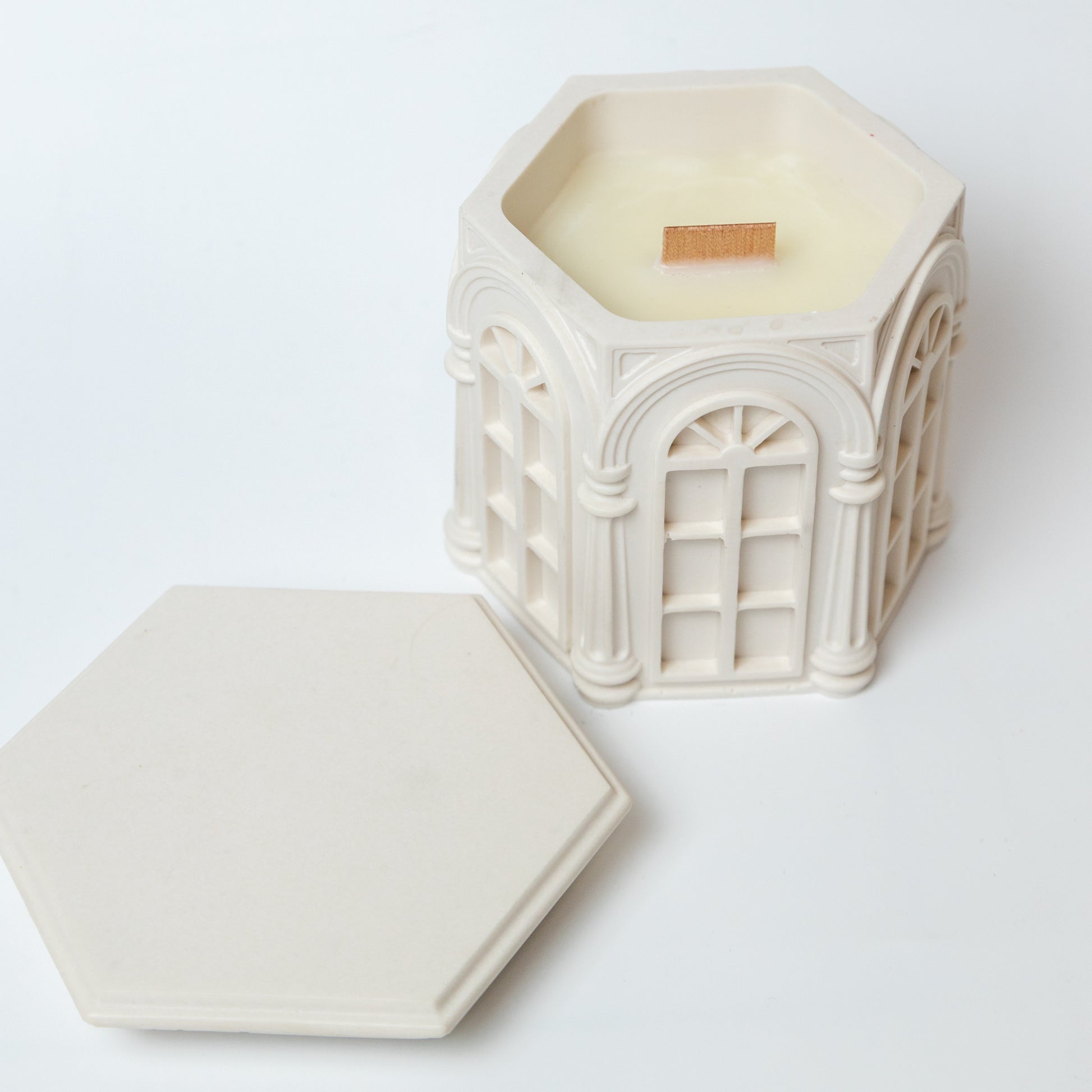 Decorative hexagonal candle with intricate design on a white background