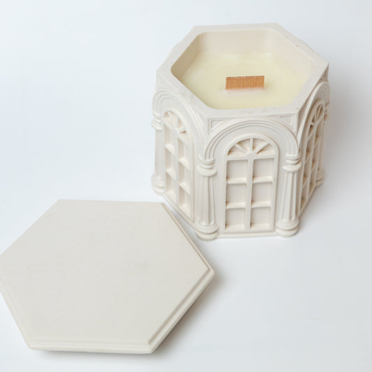 Decorative hexagonal candle with intricate design on a white background