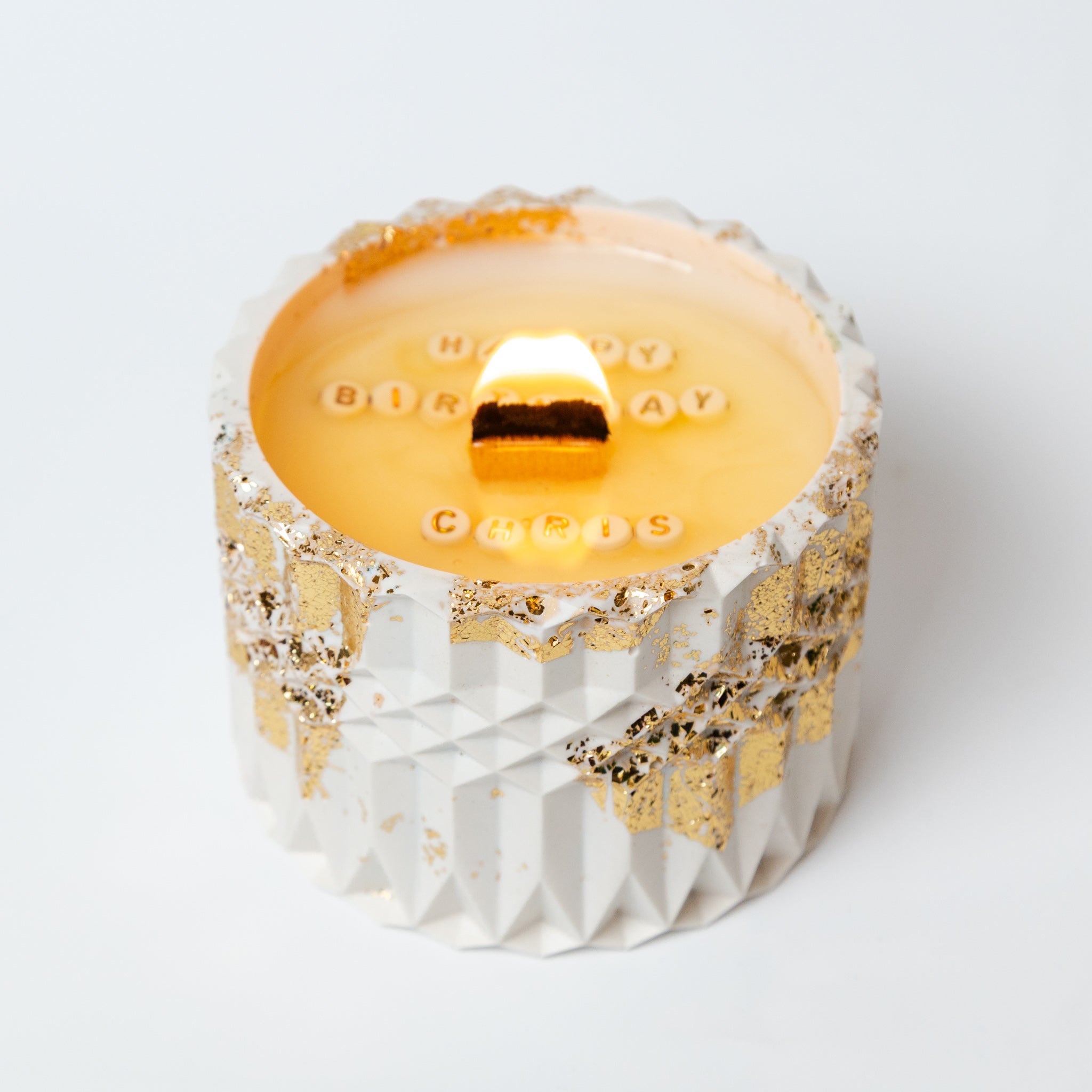 The moment of discovery in a hidden message candle, where custom text emerges through the melting natural soy wax base.