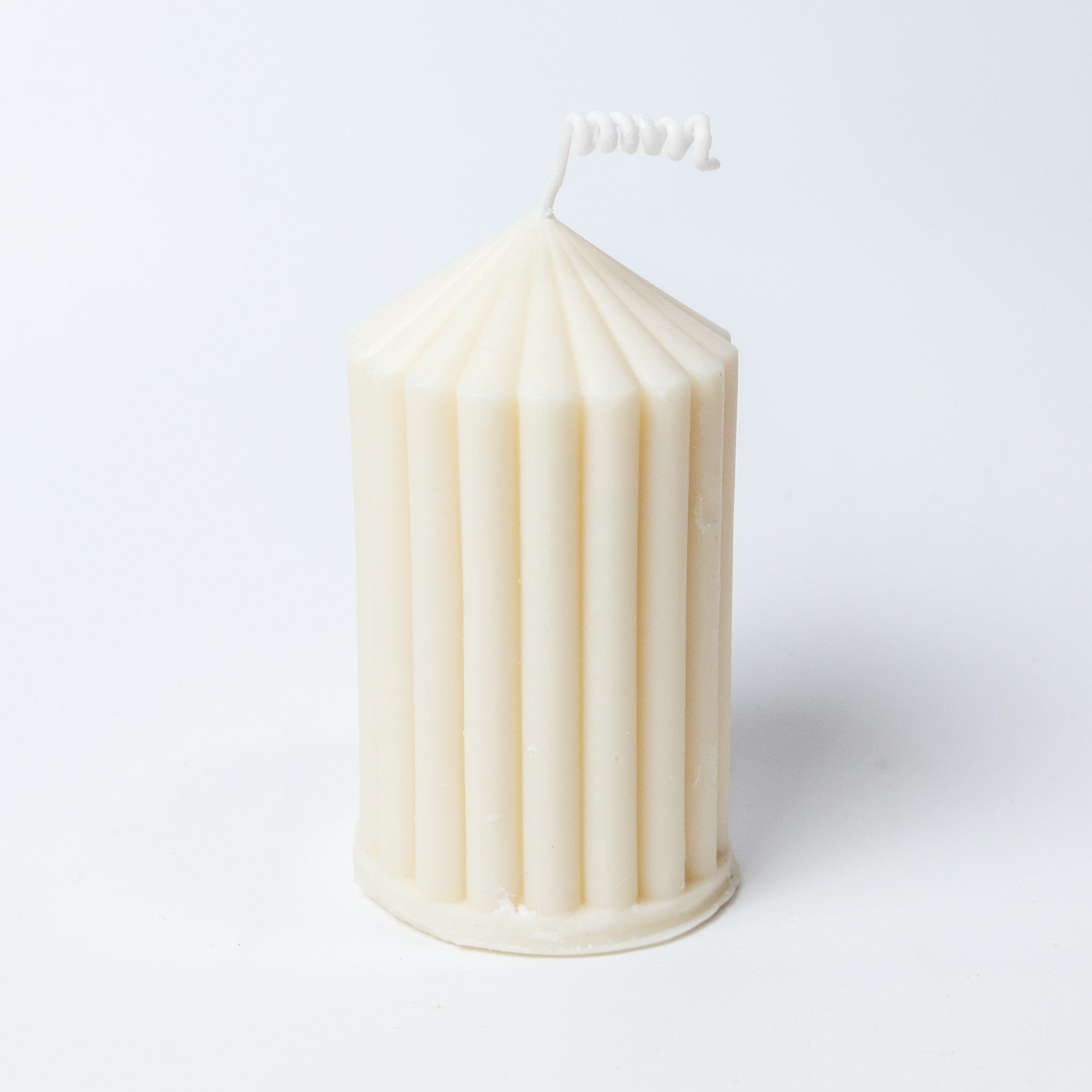 Front view of The Silence Candle in a natural, off-white hand-cast jar with natural soy wax and a single cotton wick, against a soft, unfocused background.