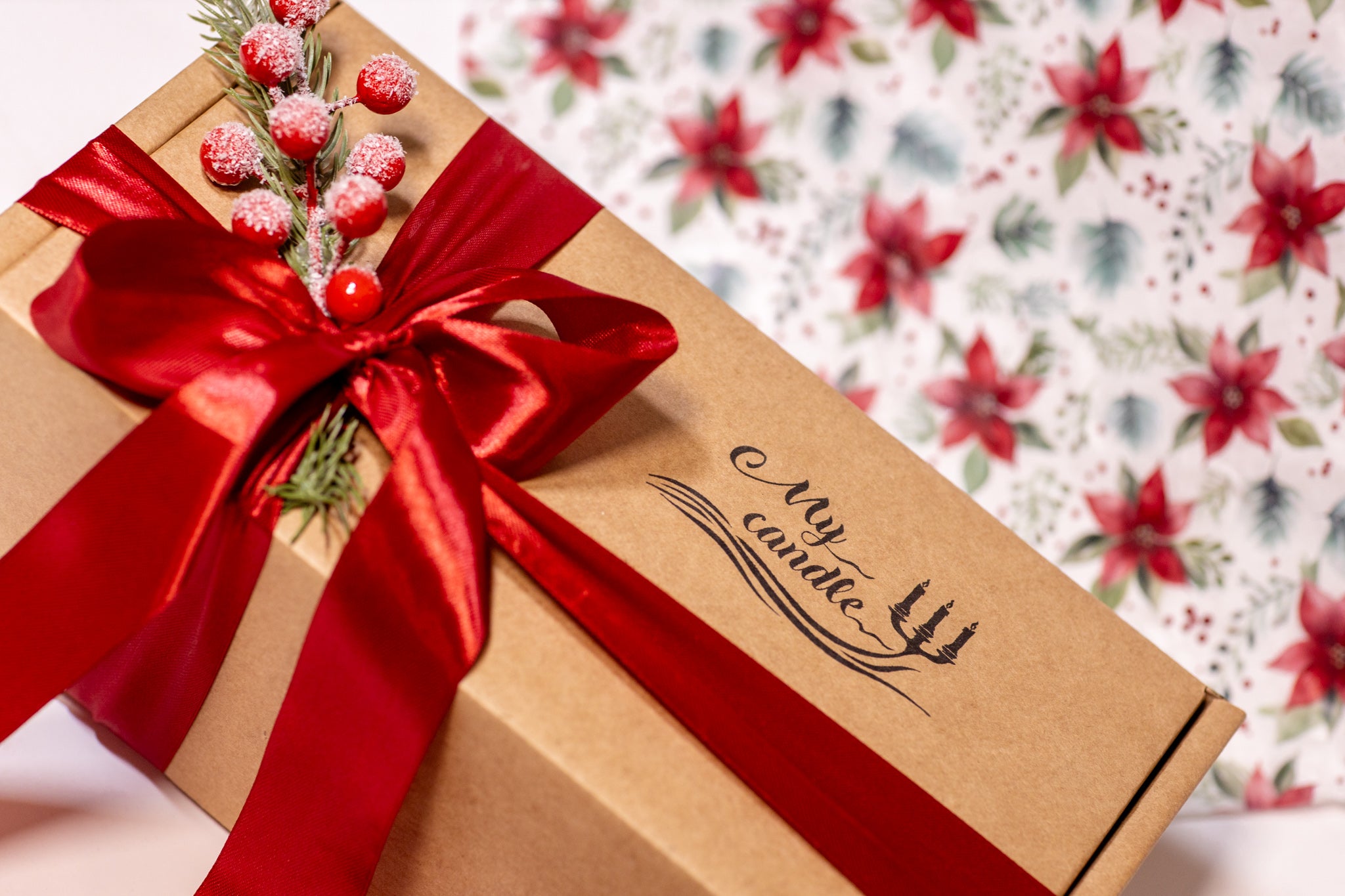 Luxury Christmas gift presentation of a personalised candle with a red ribbon and festive décor, ready for gifting.