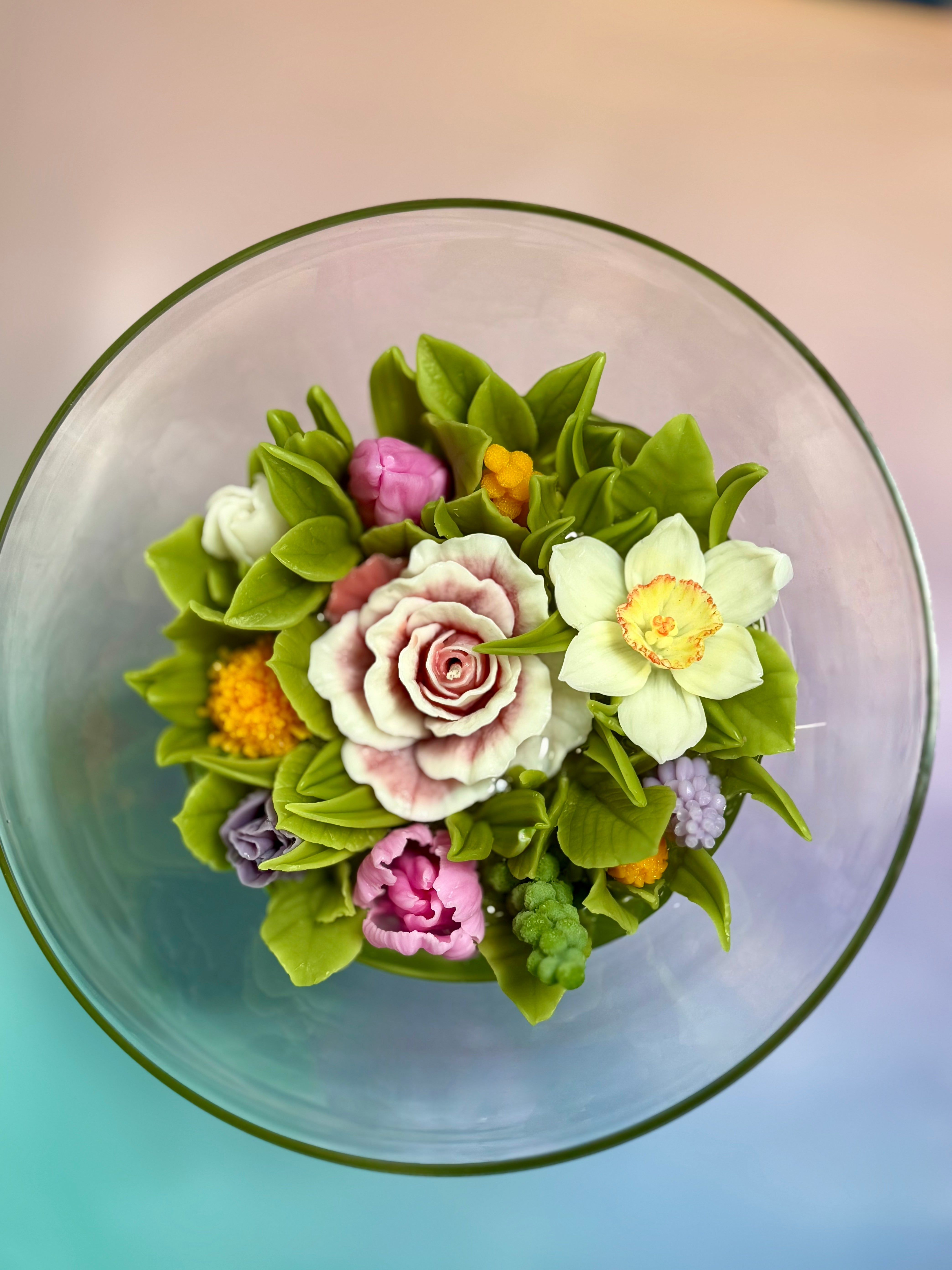Side perspective of a luxury oversized floral candle showing the depth of the clear gel and vibrant beeswax blooms.