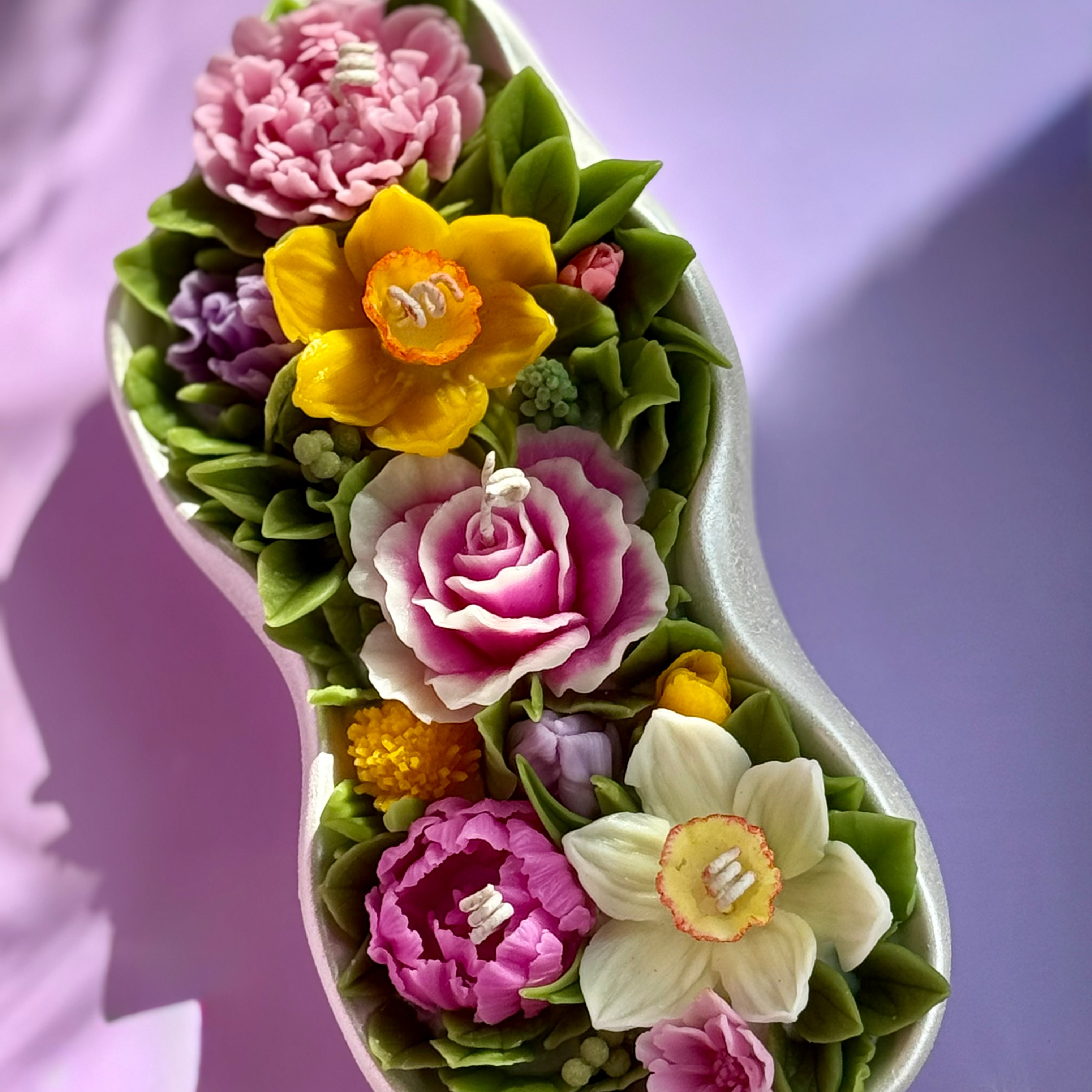 Low angle shot of the sculptural flower candle, highlighting the pearl shimmer of the vessel.