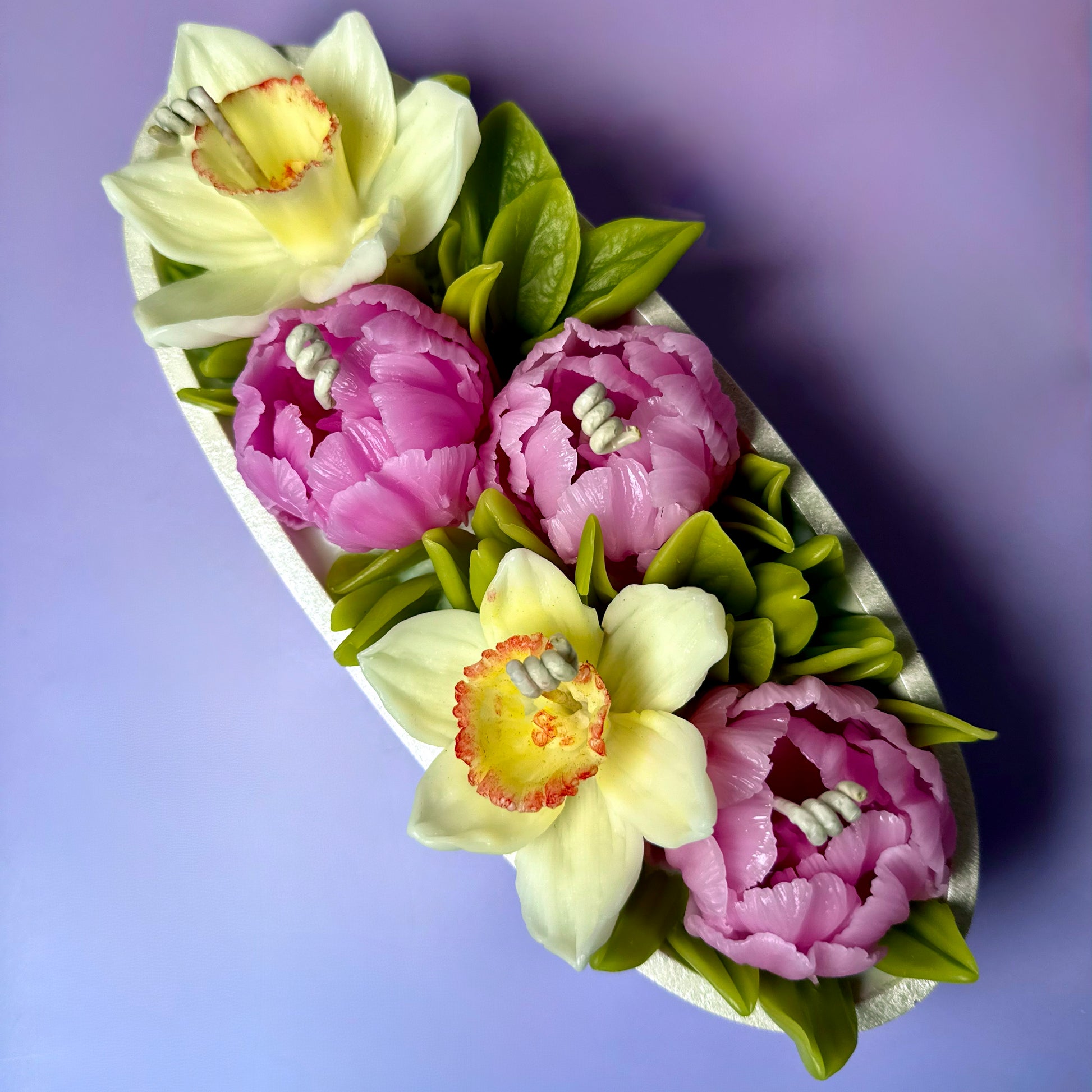 Top perspective view of intricately handcrafted beeswax flowers on a clean soy wax base.