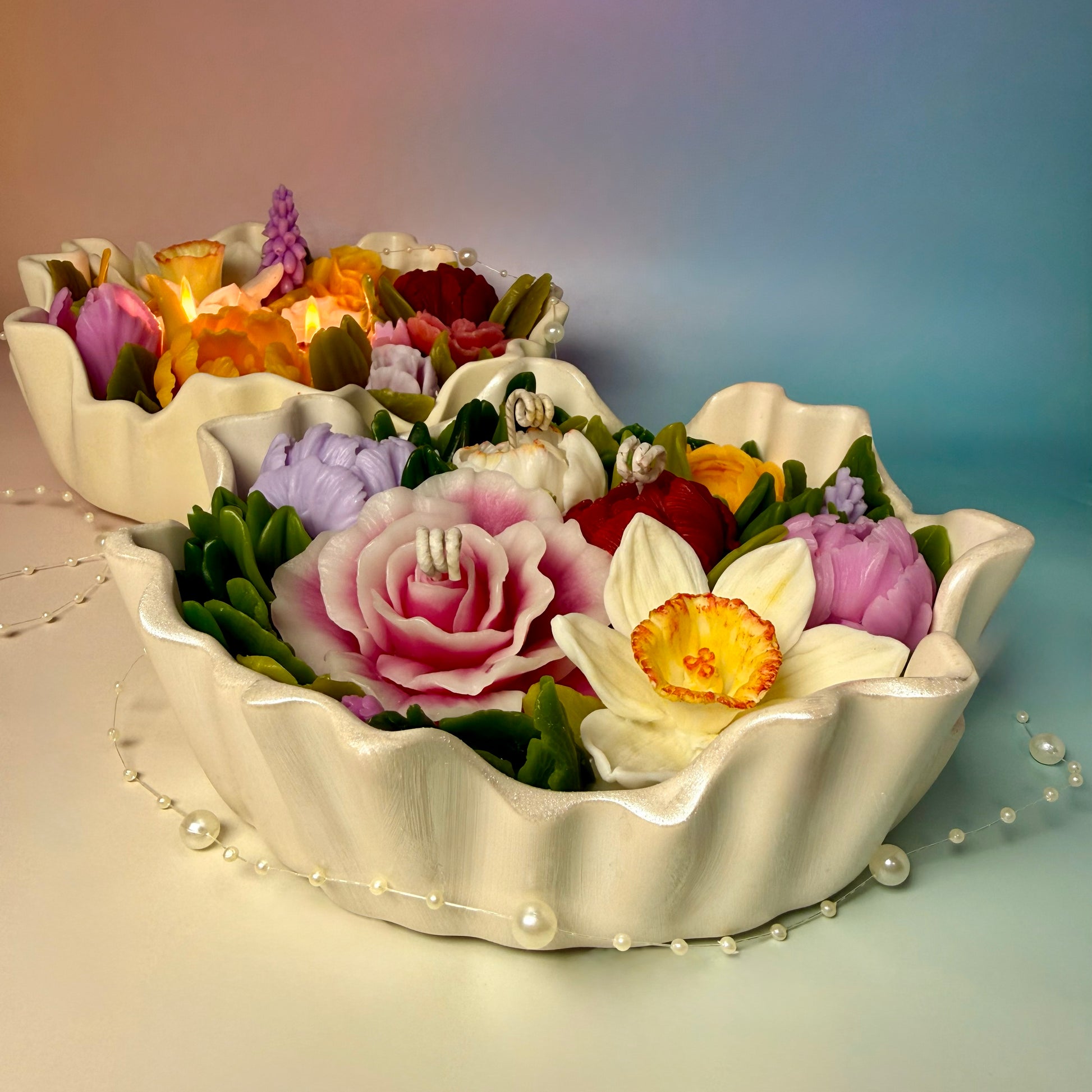Perspective view of two "Flower Meadow" candles, highlighting the intricate petal details.