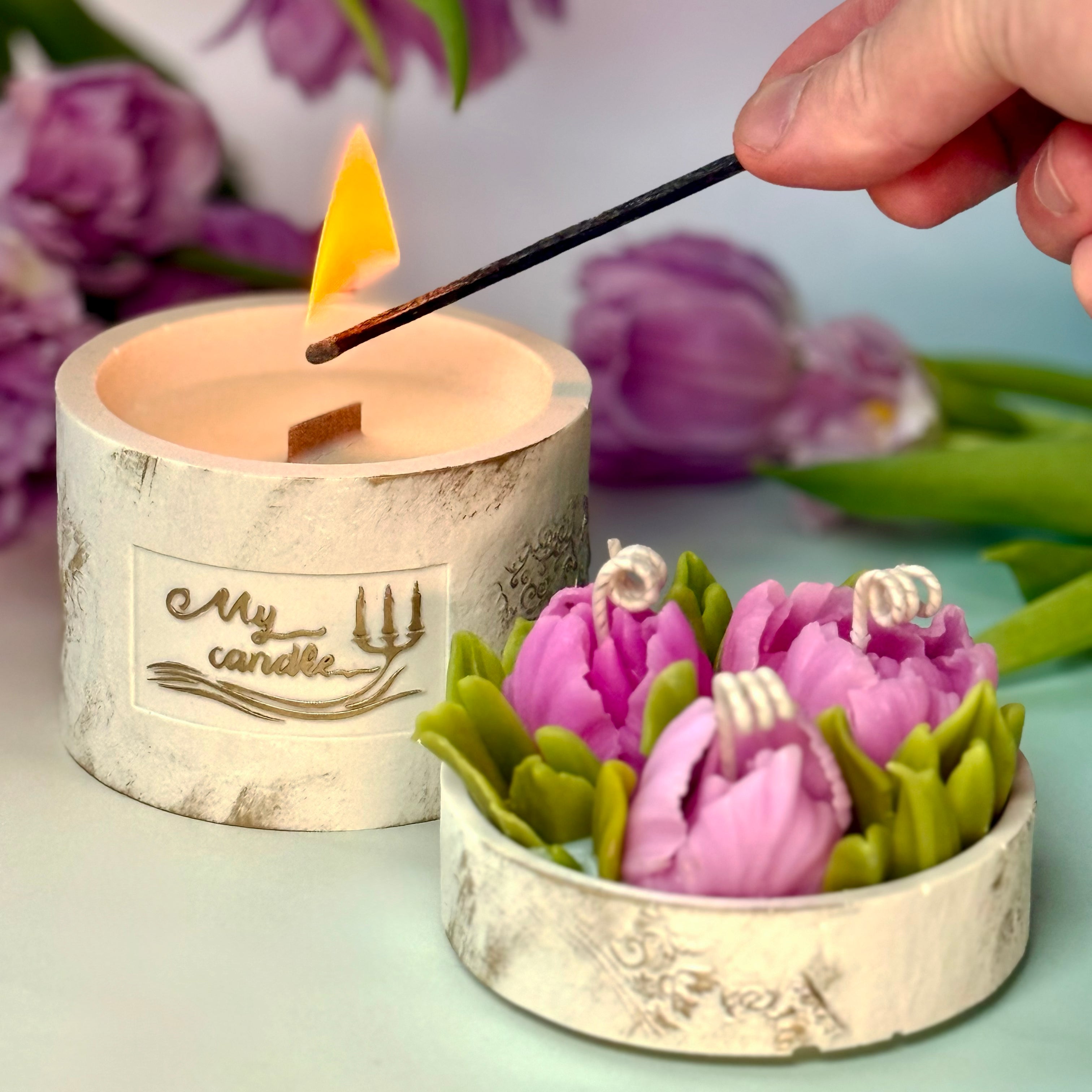 Atmospheric shot of a burning multi-wick peony tulip flower candle, displaying glowing flames among sculpted artisan wax petals with gift box.