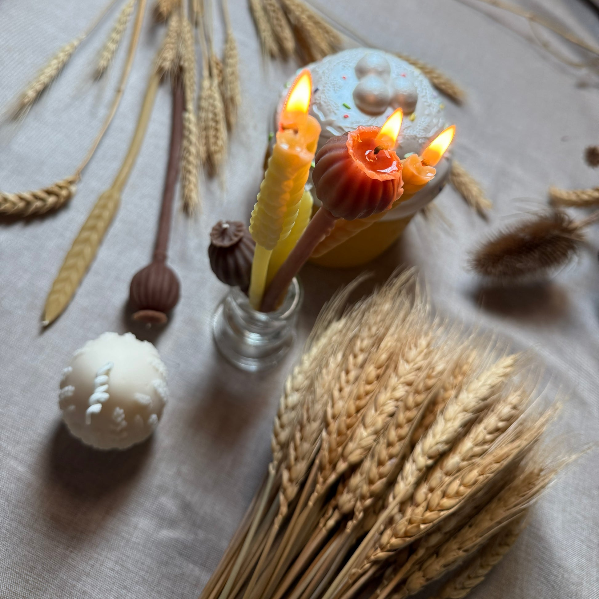 A detailed macro close-up of the Wheat Stalk taper candle, highlighting the intricate 3D relief texturing of the individual grains moulded into the golden ivory natural beeswax.