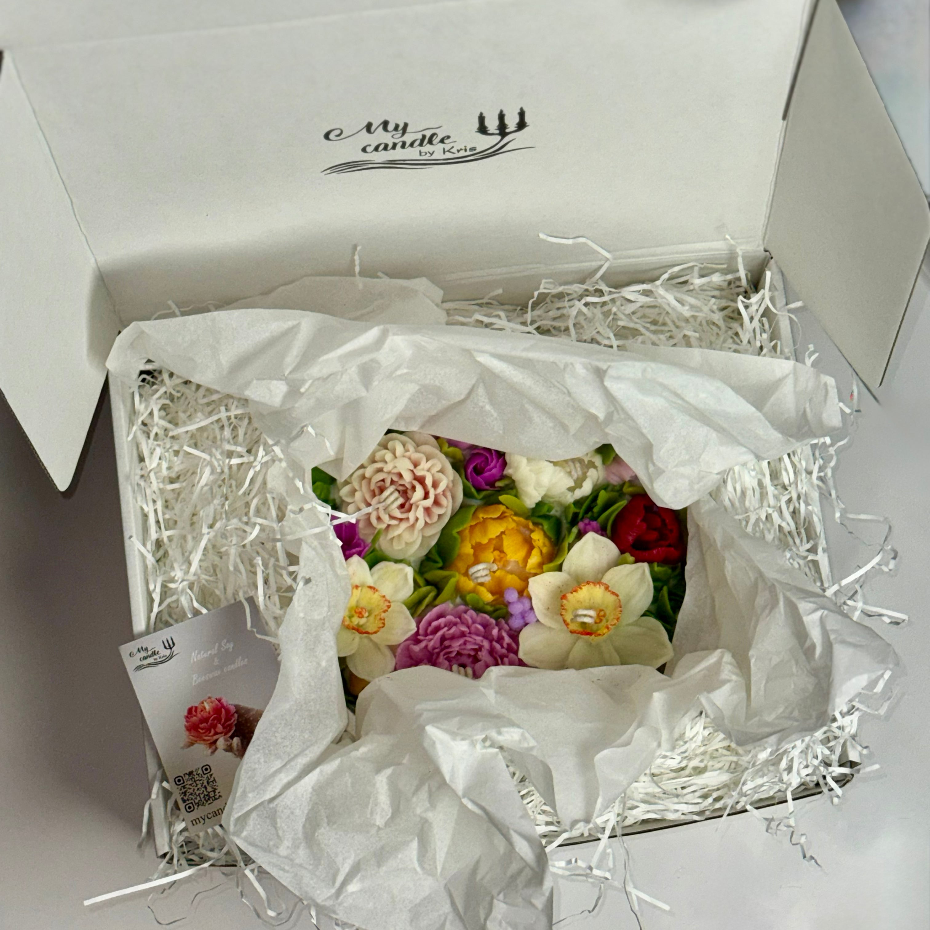Top view of the gift box interior with a multi-coloured floral candle ready for gifting.