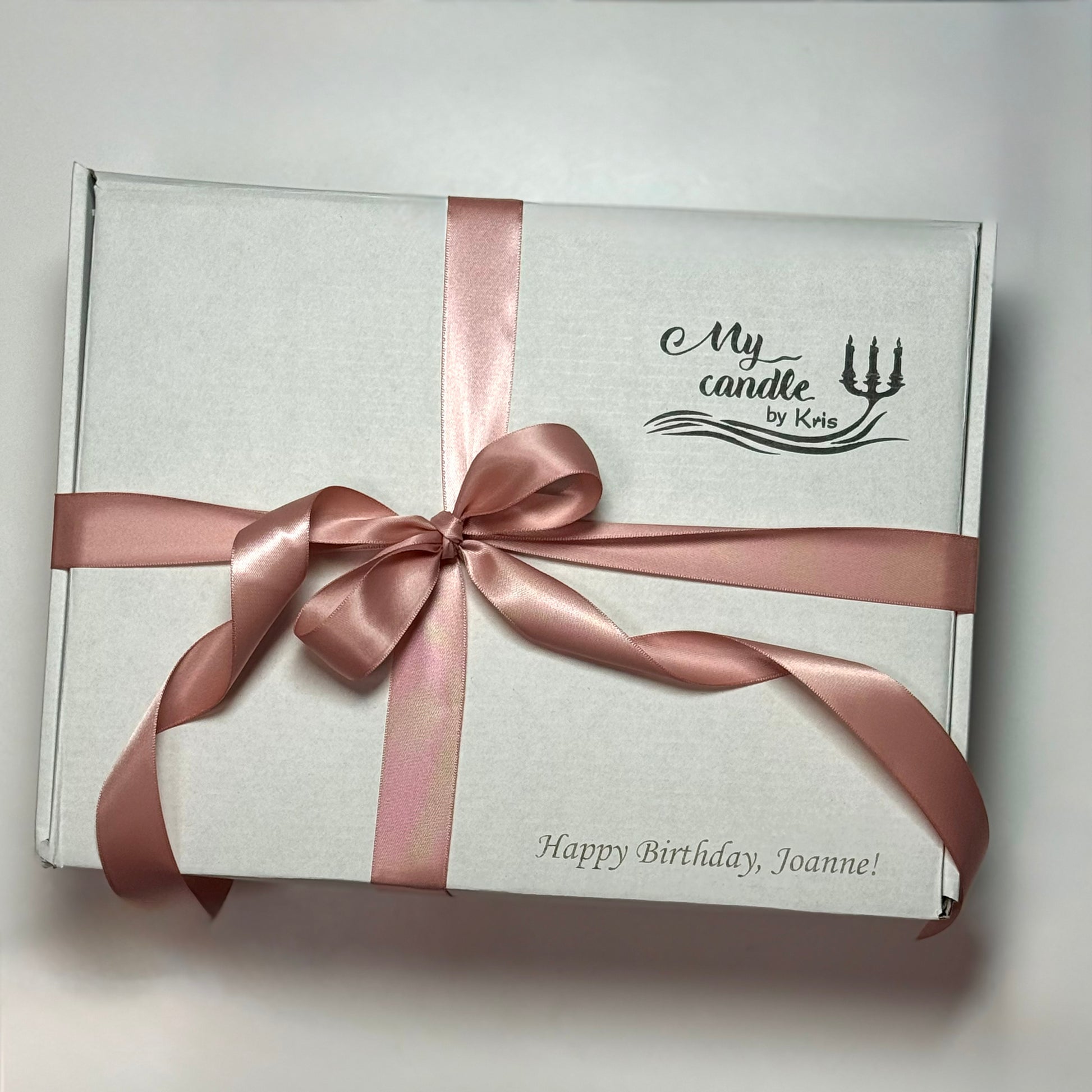 High-end gift packaging with a pink ribbon and custom 'Happy Birthday' engraving on the box.