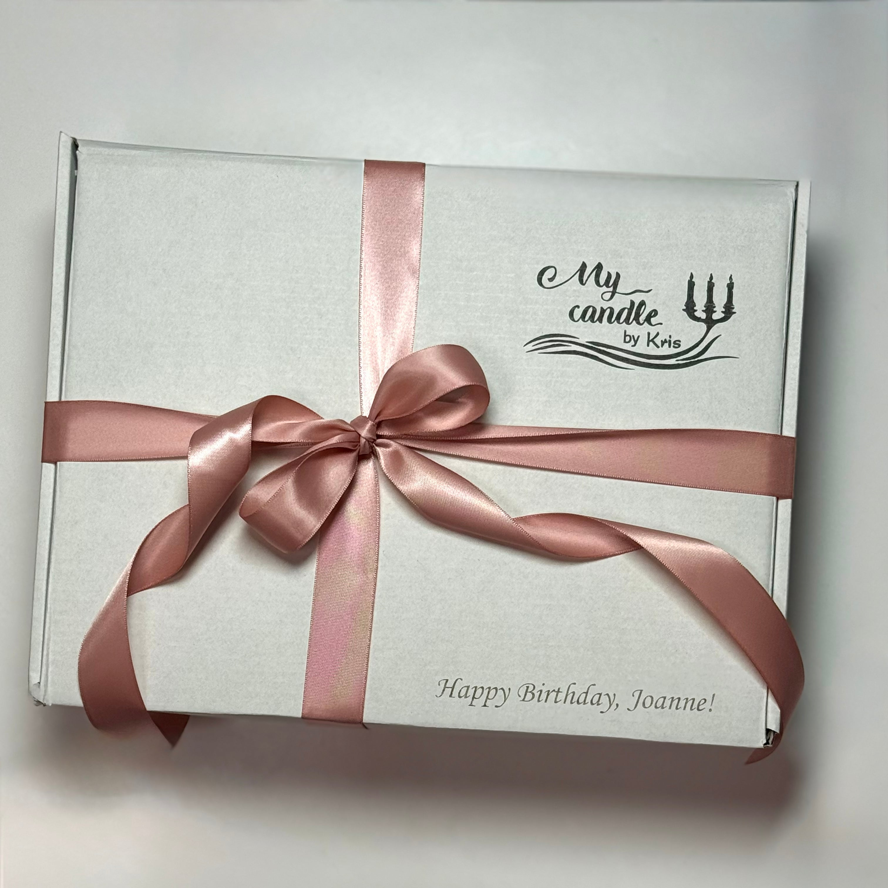 High-end gift packaging with a pink ribbon and custom 'Happy Birthday' engraving on the box.