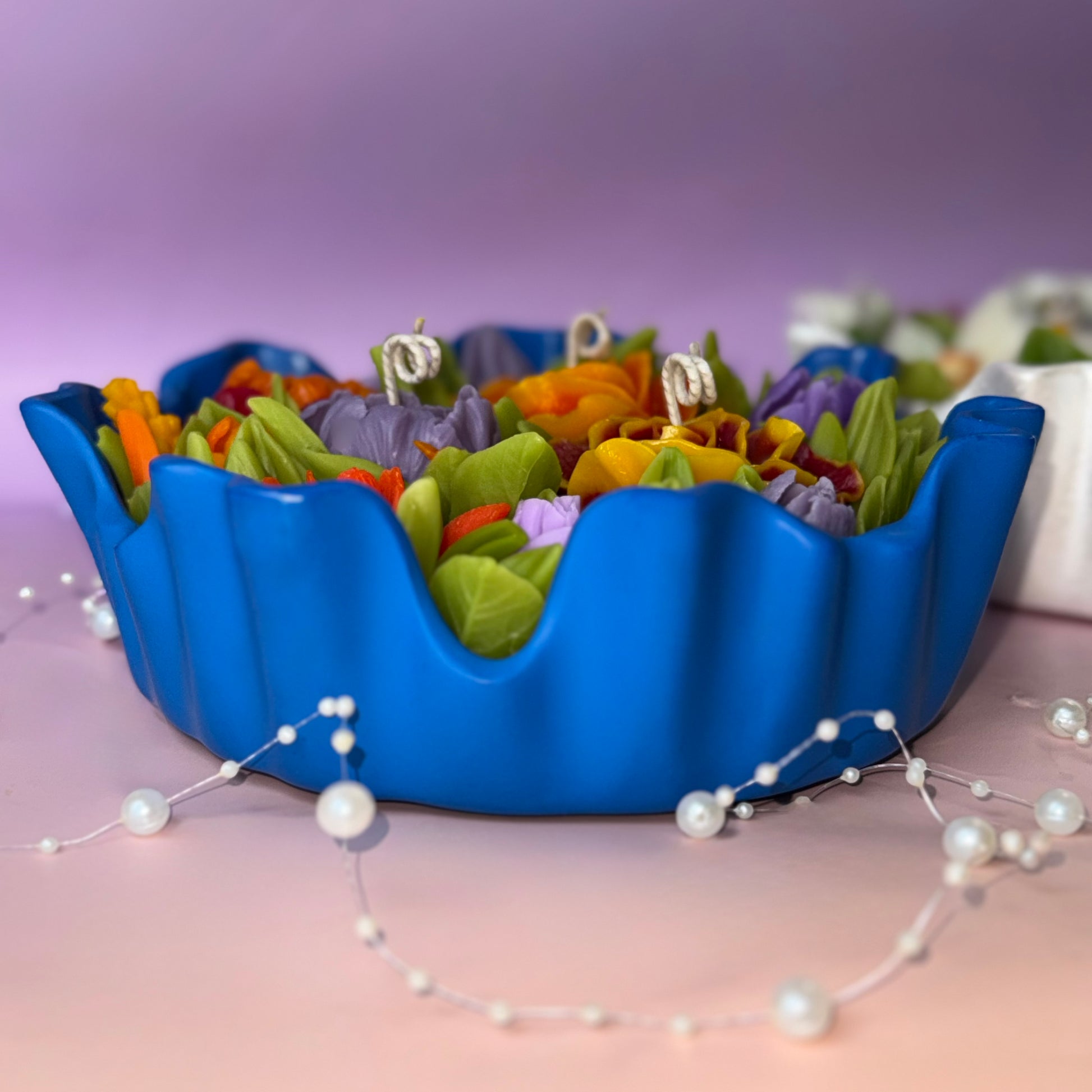 Side view of the azure blue fluted Jesmonite dish with botanical wax flower arrangement.