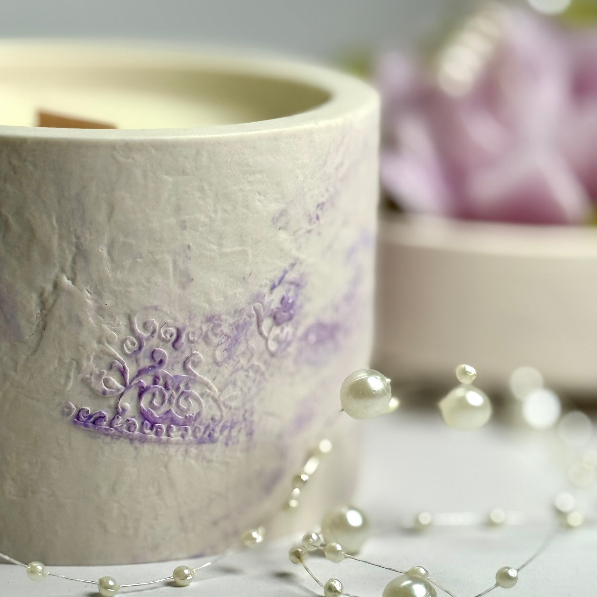 Macro shot of the unique hand-painted purple texture on the artisan-crafted candle vessel.