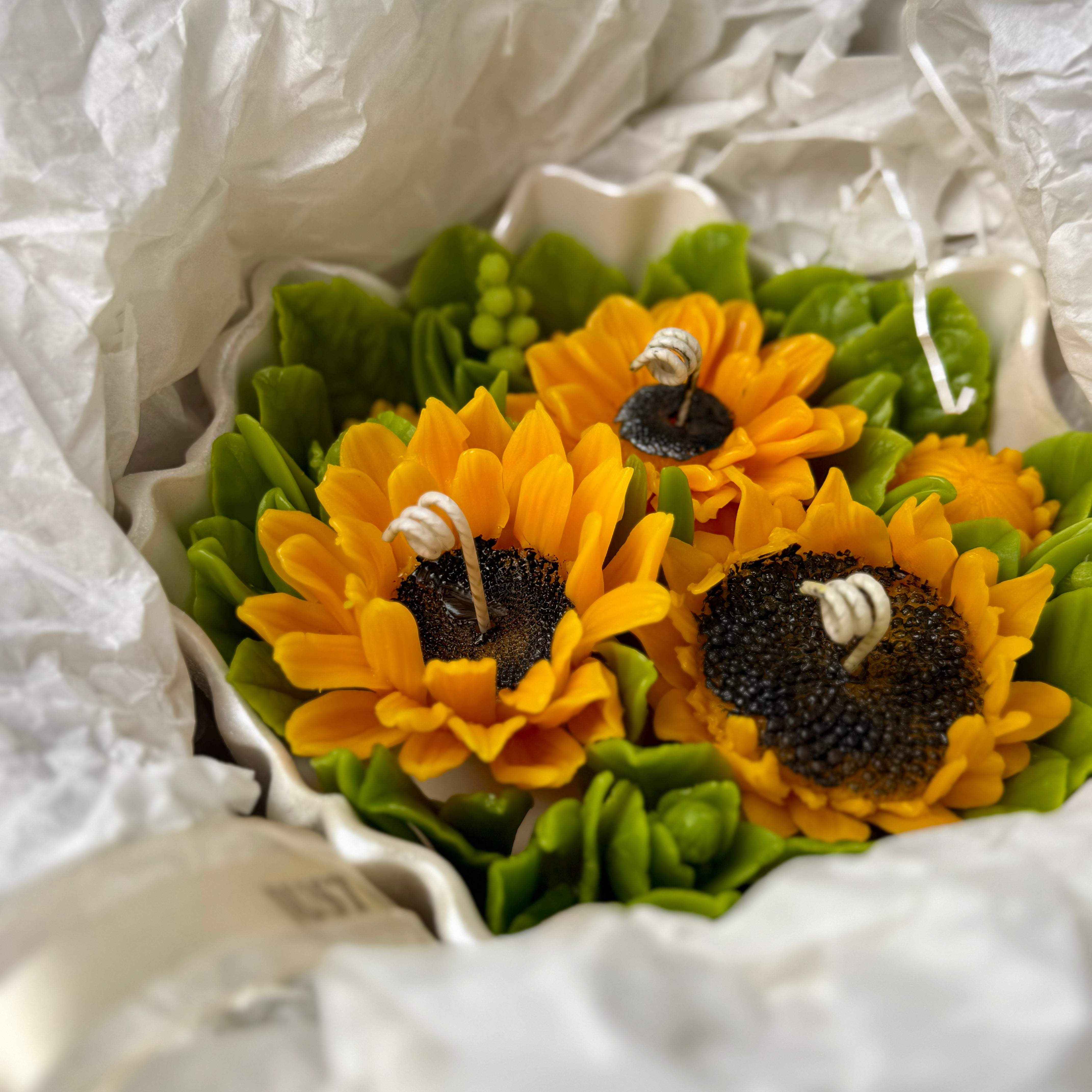 Beautifully crafted sunflower and botanical foliage candle arrangement with decorative curled cotton wicks packed as a premium personalised gift.