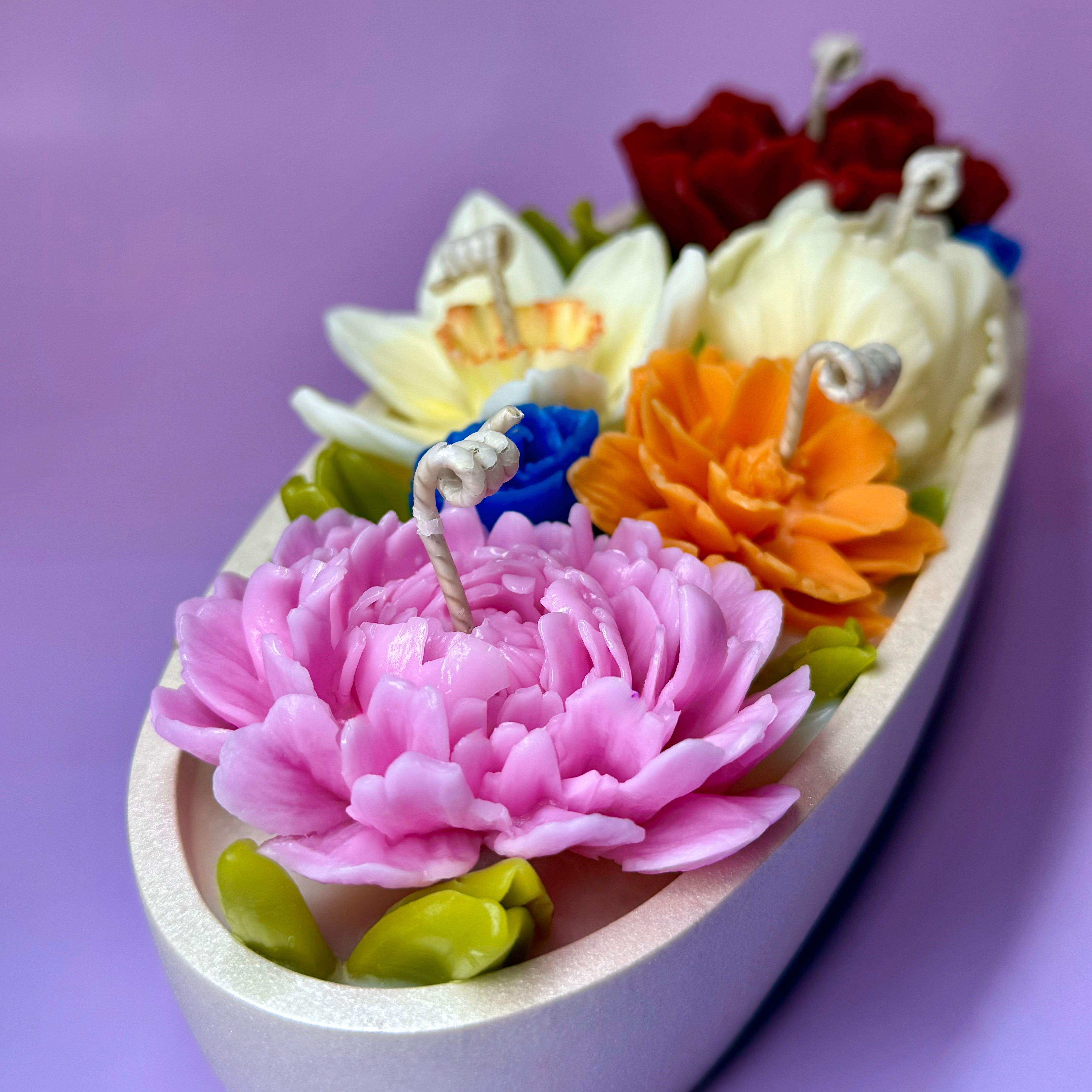 High-angle shot of the "Flower Meadow" 5-wick candle centrepiece on a soft purple background.