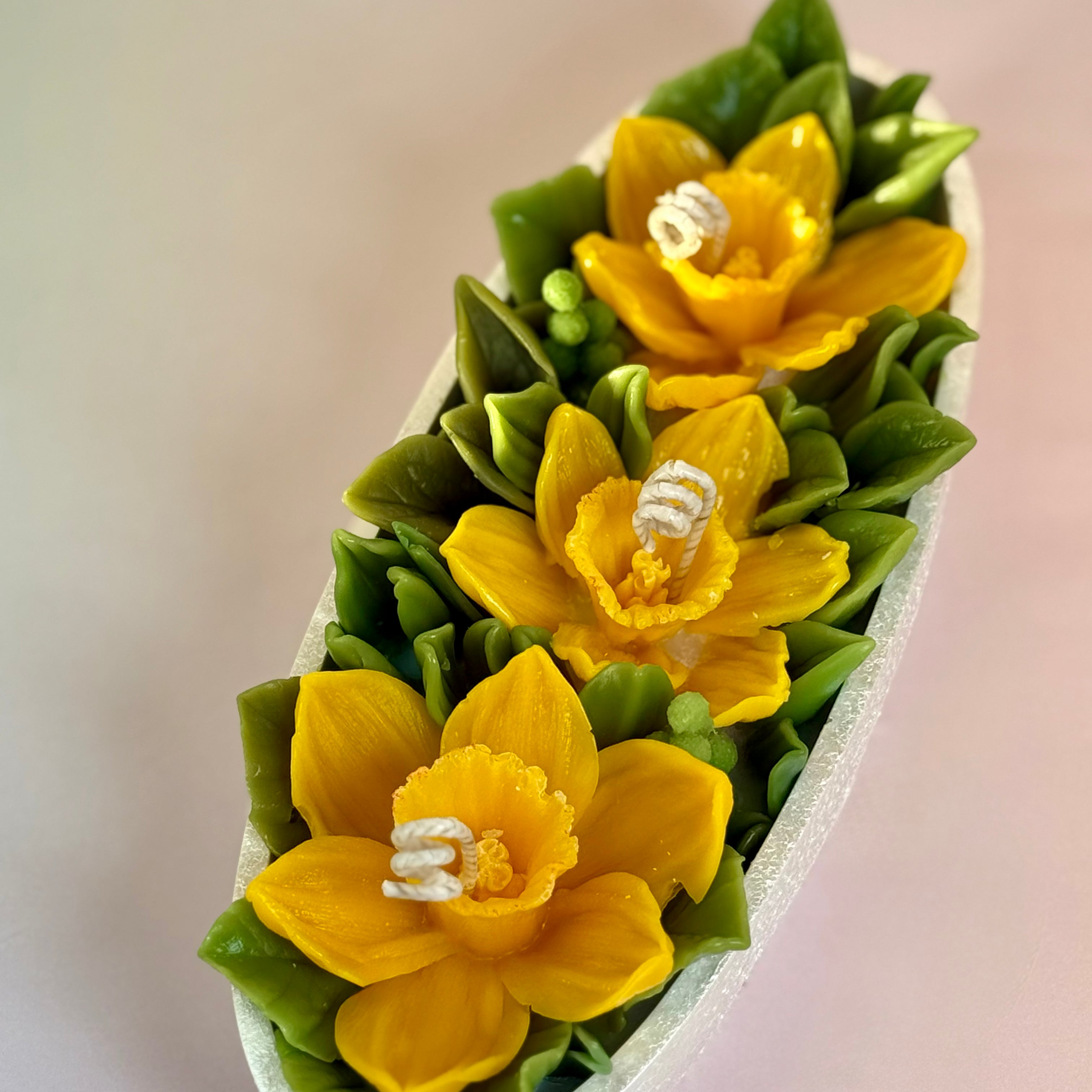 Low angle view of the pearl-white hand-painted Jesmonite tray with yellow flower candles.