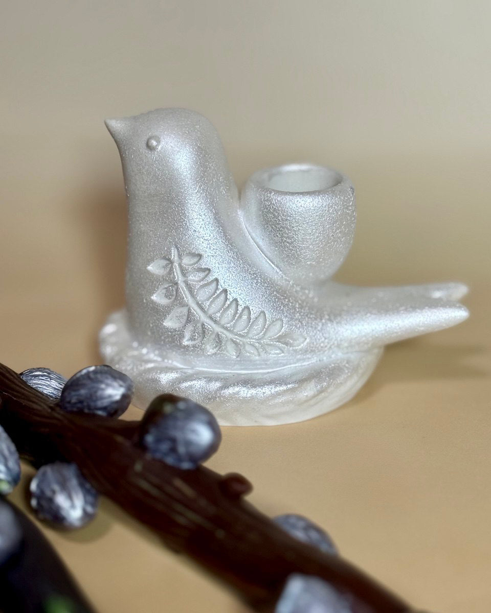 Close-up macro shot of the empty unpainted pearl-white Jesmonite bird candle holder with a 25mm socket, highlighting its smooth texture and woven nest base design.