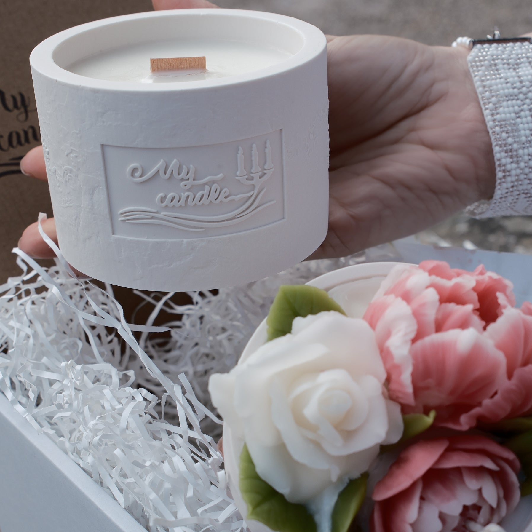 Showcase of the two-part modular candle system with floral wax art and a pearl-white artisan pot.
