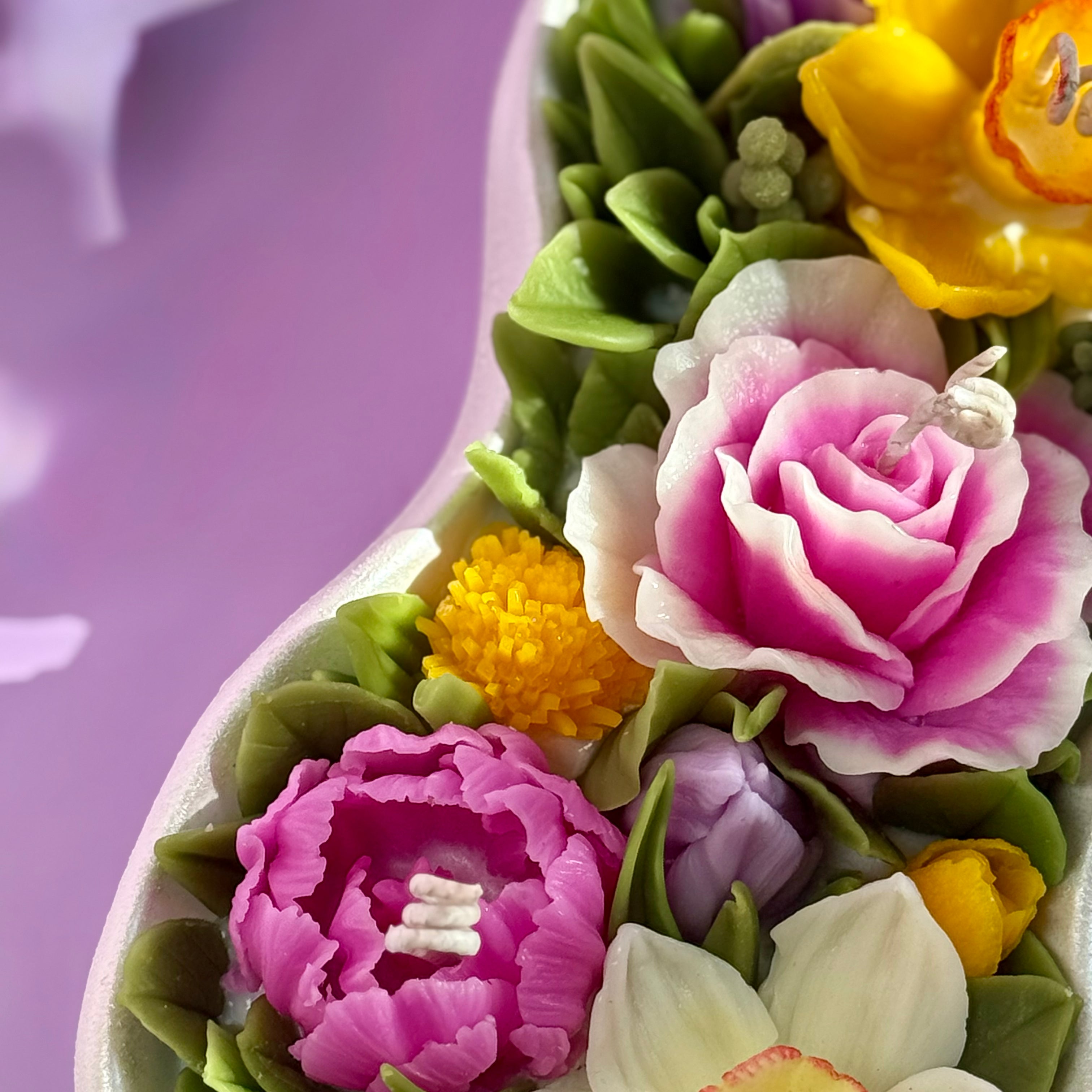 Close up of the hand-painted pearl white wave-shaped Jesmonite tray and pink wax rose.