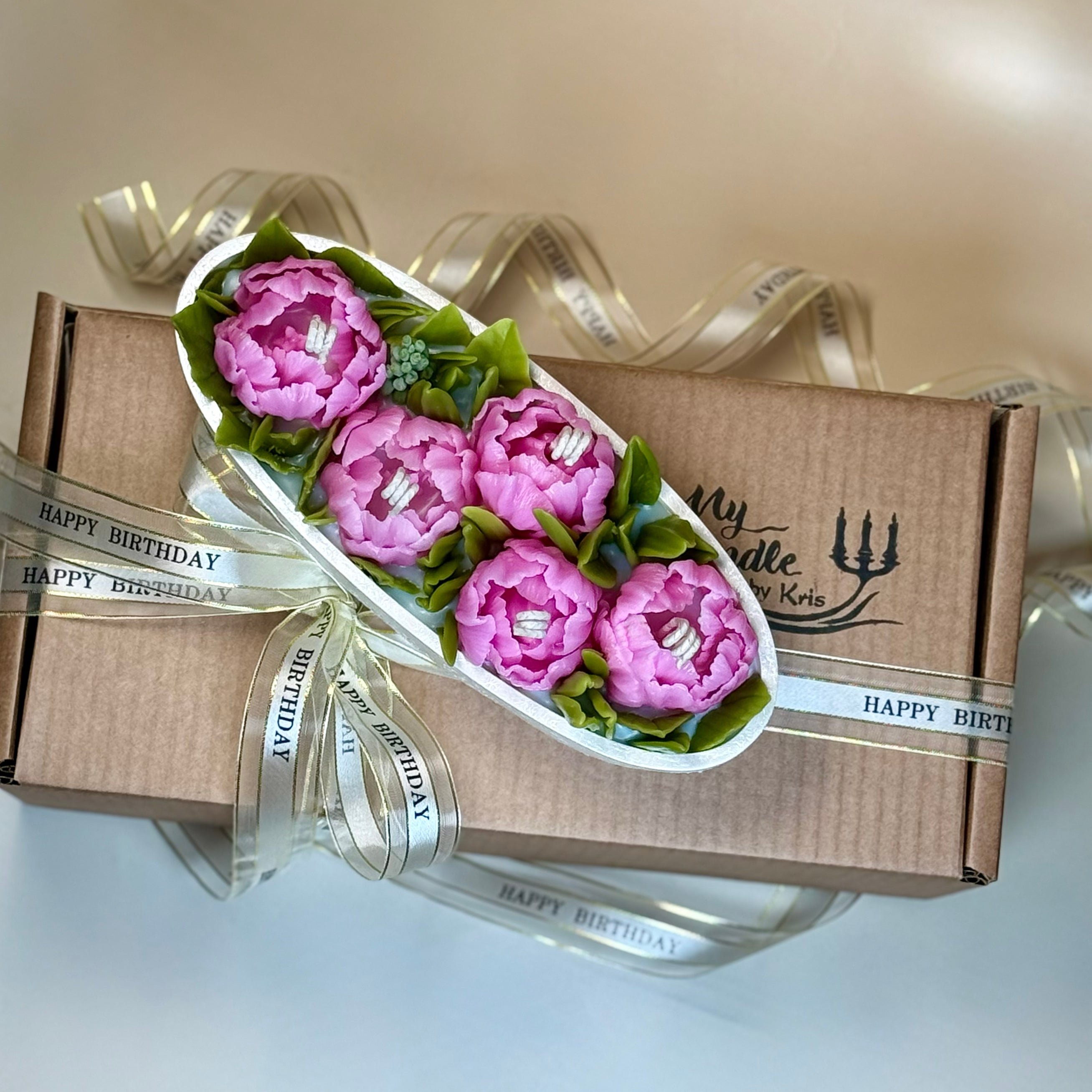 Top-down view of a bespoke peony flower candle set placed over its branded My Candle by Kris kraft paper gift box, styled with a festive birthday ribbon with gift box.