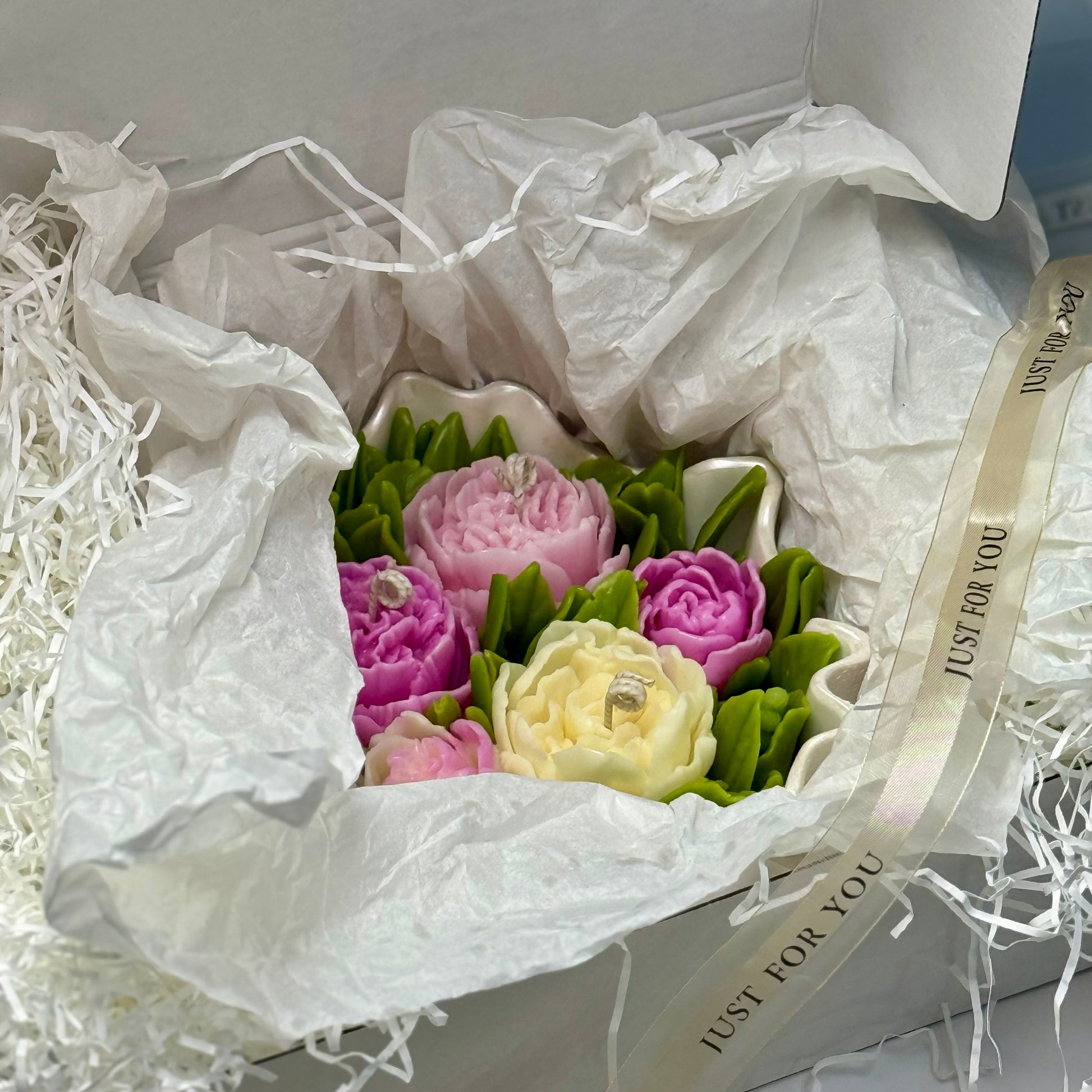 The 20cm scalloped pearl white Jesmonite peony candle bowl wrapped in tissue inside a luxury gift box that features an option for custom laser engraving.