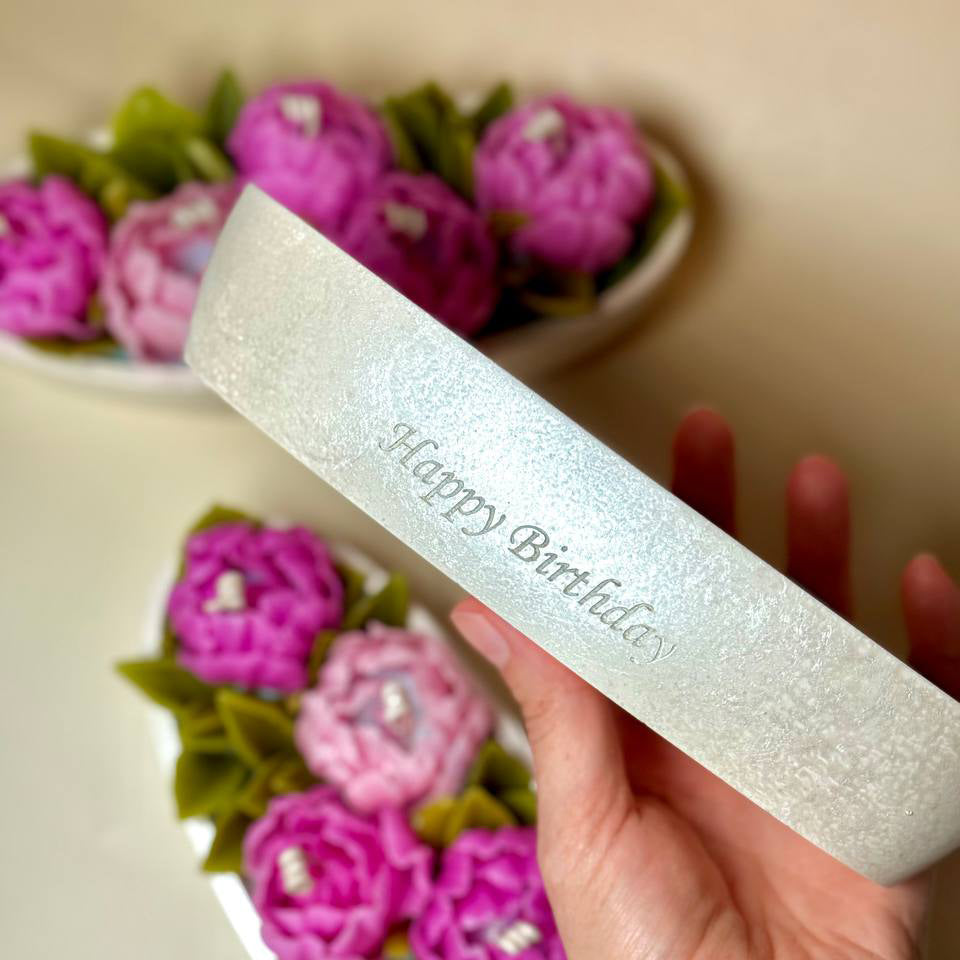 Close up of custom 'Happy Birthday' engraving on a pearl white hand-painted Jesmonite pot.
