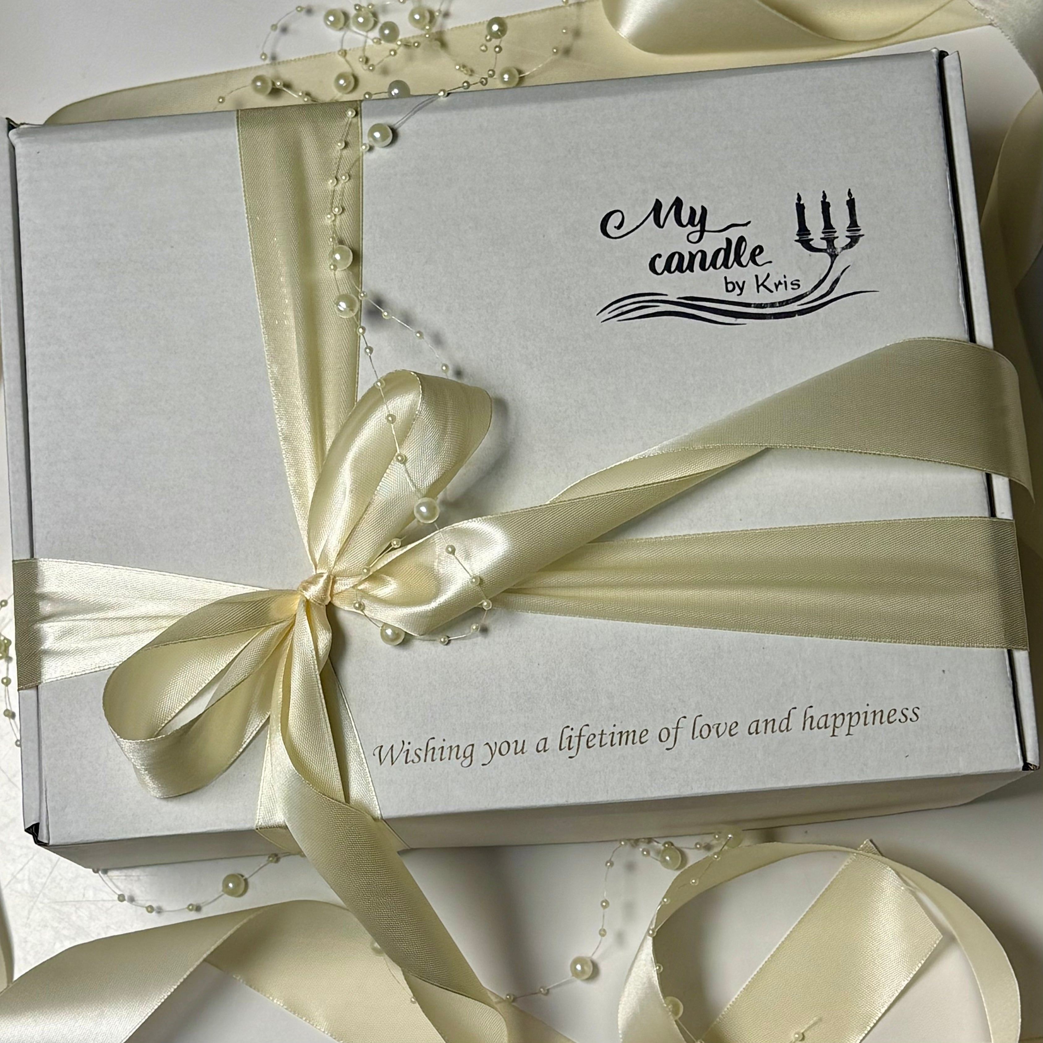 Elegant white presentation gift box from My Candle by Kris, beautifully tied with a ivory satin ribbon, featuring custom laser engraving that reads Wishing you a lifetime of love and happiness.