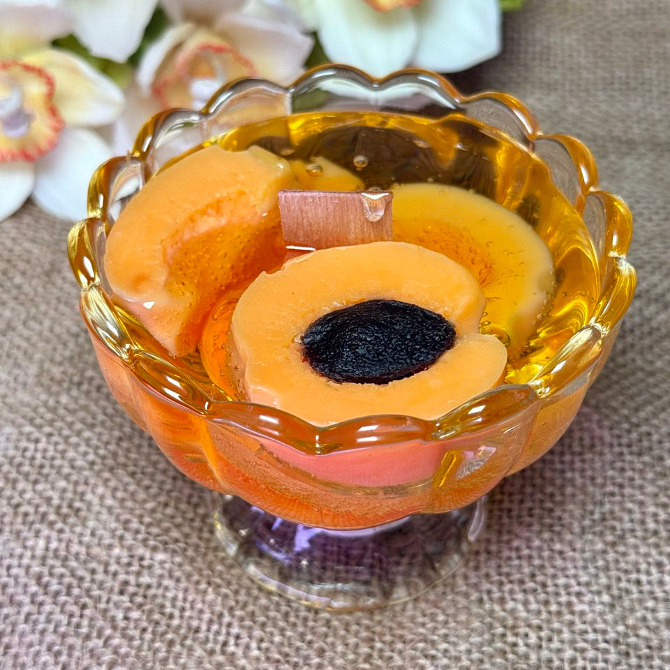 Realistic apricot jam candle in a glass dessert bowl with handcrafted beeswax fruit