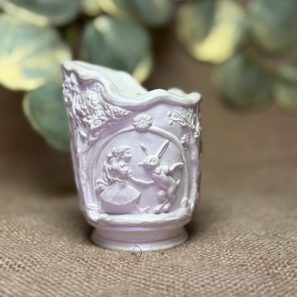 Bespoke Pure Pearl-White edition of the Alice in Wonderland scenic candle, highlighting the minimalist sculptural high-relief details of the fairy tale characters with a soft pearlescent glow