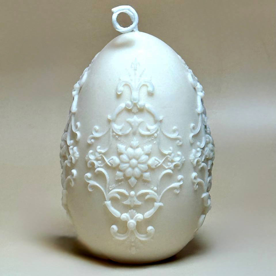 Front view of The Royal Pysanka ornate Baroque Easter egg soy candle in off-white with detailed botanical filigree patterns against a neutral background.