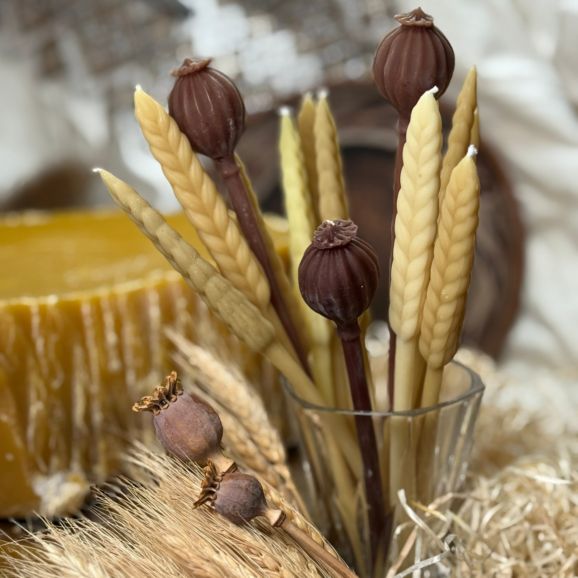 A close-up view of the sculptural Poppy Pod candle, showing the realistic crown and vertically ridged earthy texture of the hand-poured natural beeswax figurine.