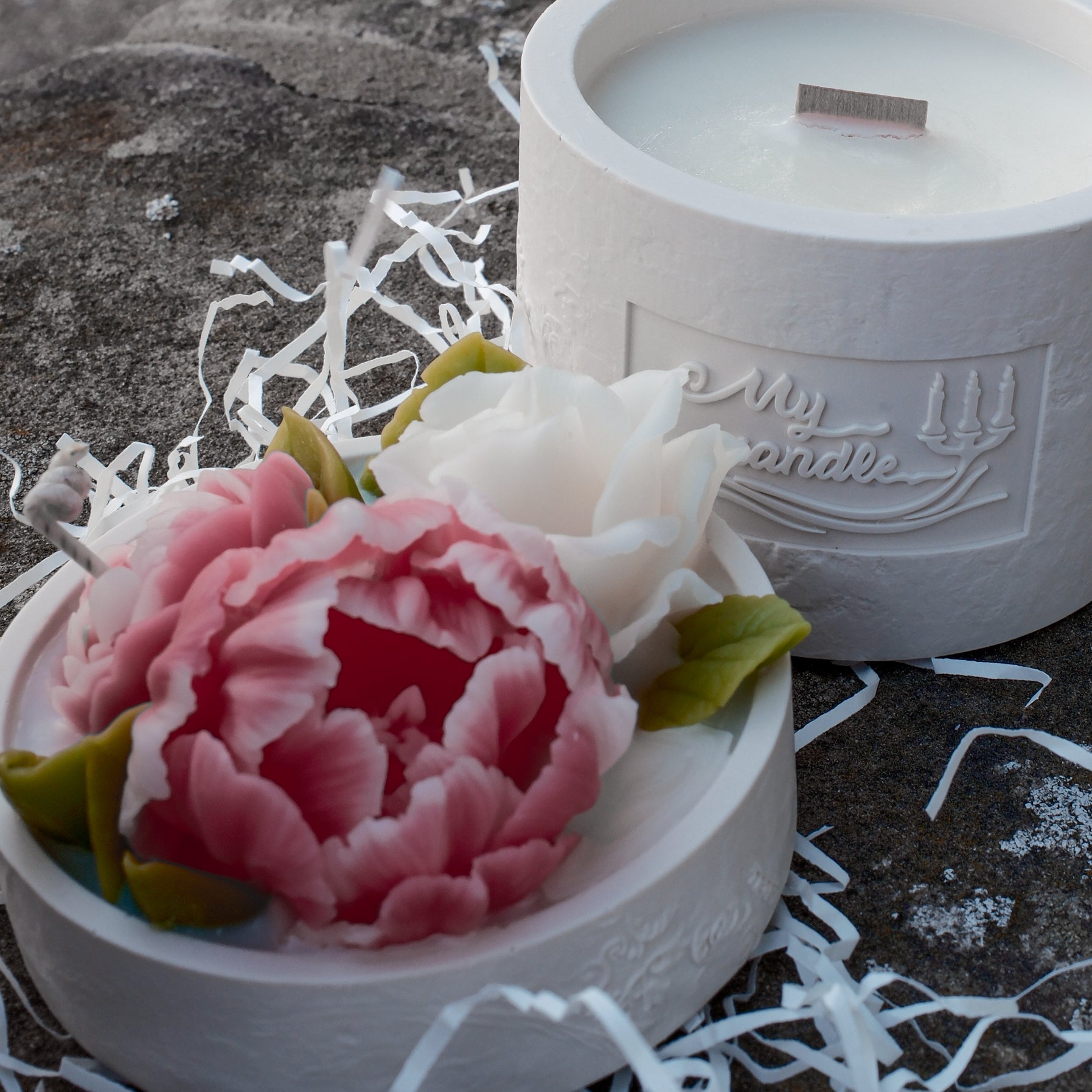 Handcrafted Jesmonite candle base with a natural wooden wick nestled in eco-friendly white shredded paper.